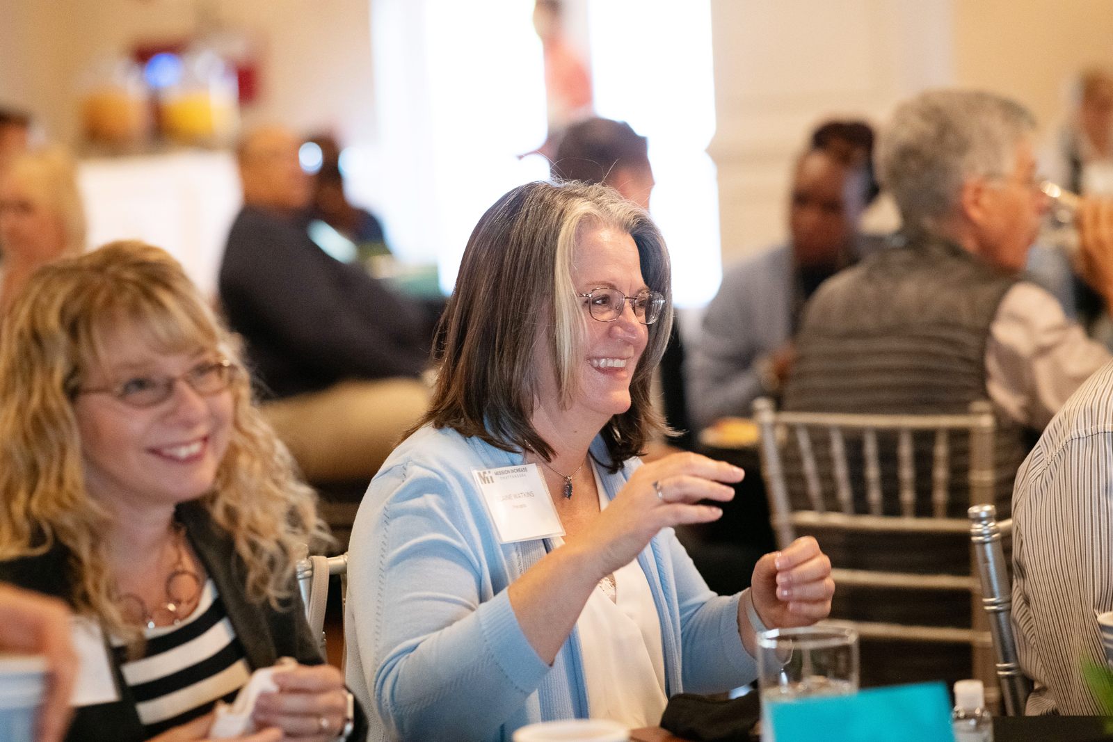 Two attendees laughing together during a Mi Gulf Coast luncheon