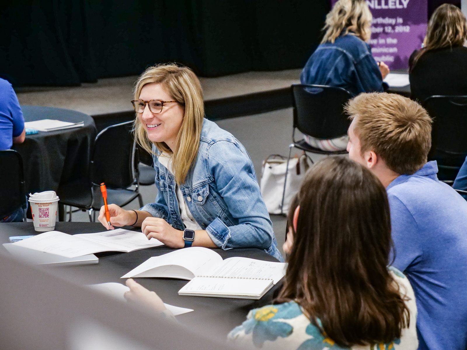 A workshop participant smiling while working through a training workbook